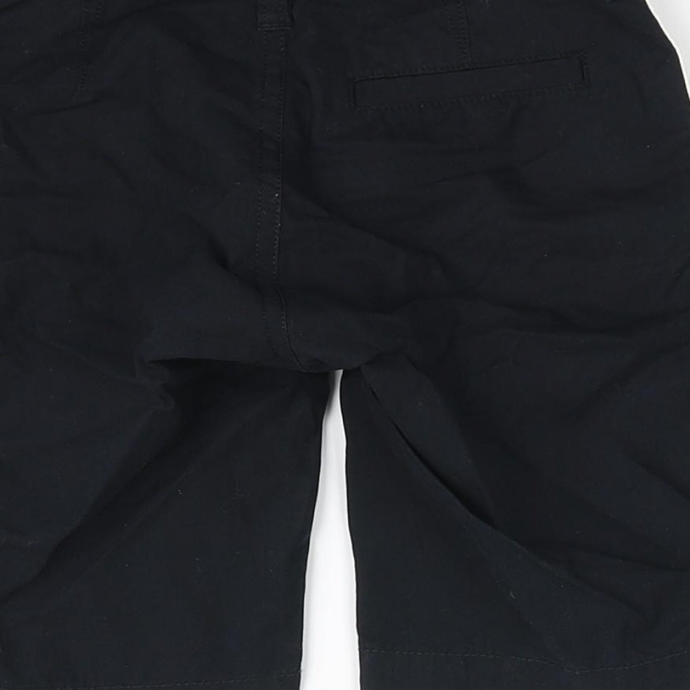Brand and care label for Guess kids girls’ black chino shorts, size 7, years