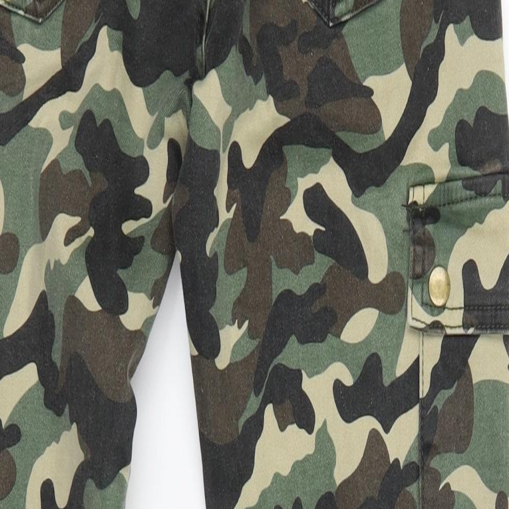 Brand and care label for Monday girls’ green camouflage tapered jeans, size XL