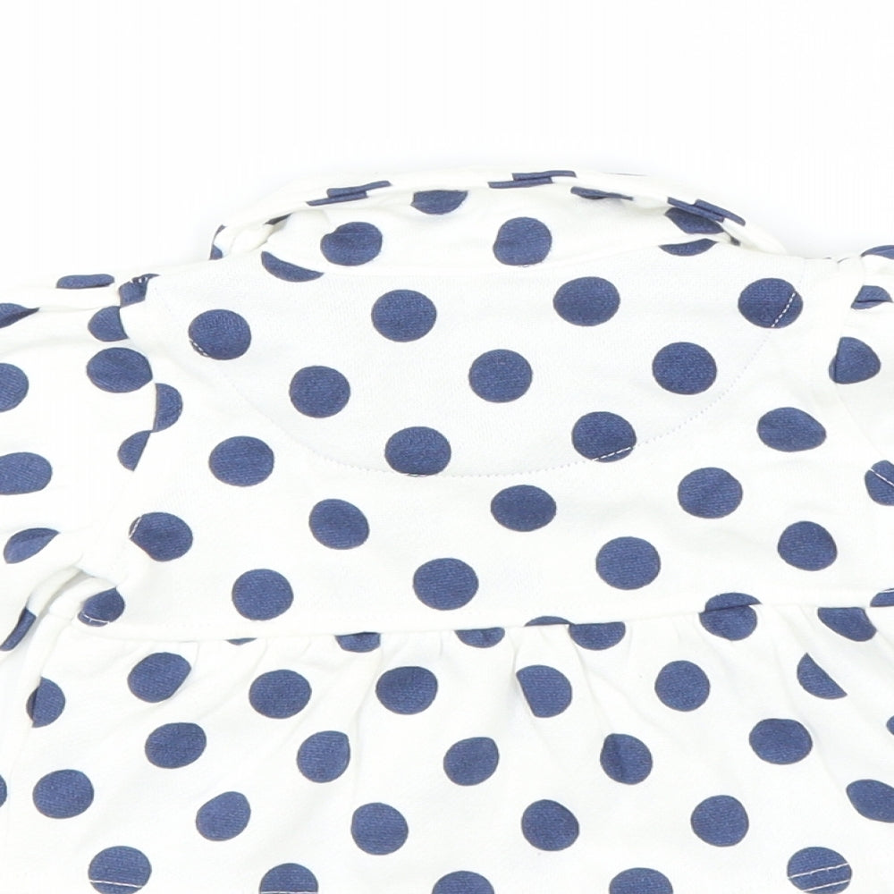 Brand and care label for Early Days girls’ white polka dot jacket, size 3-6, months