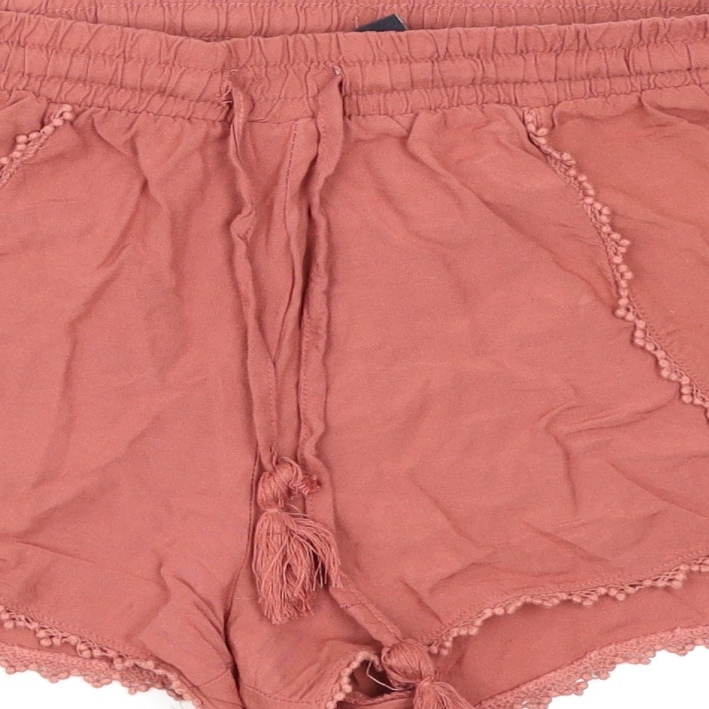 Brand and care label for Atmosphere women’s red cut-off shorts, size UK 8