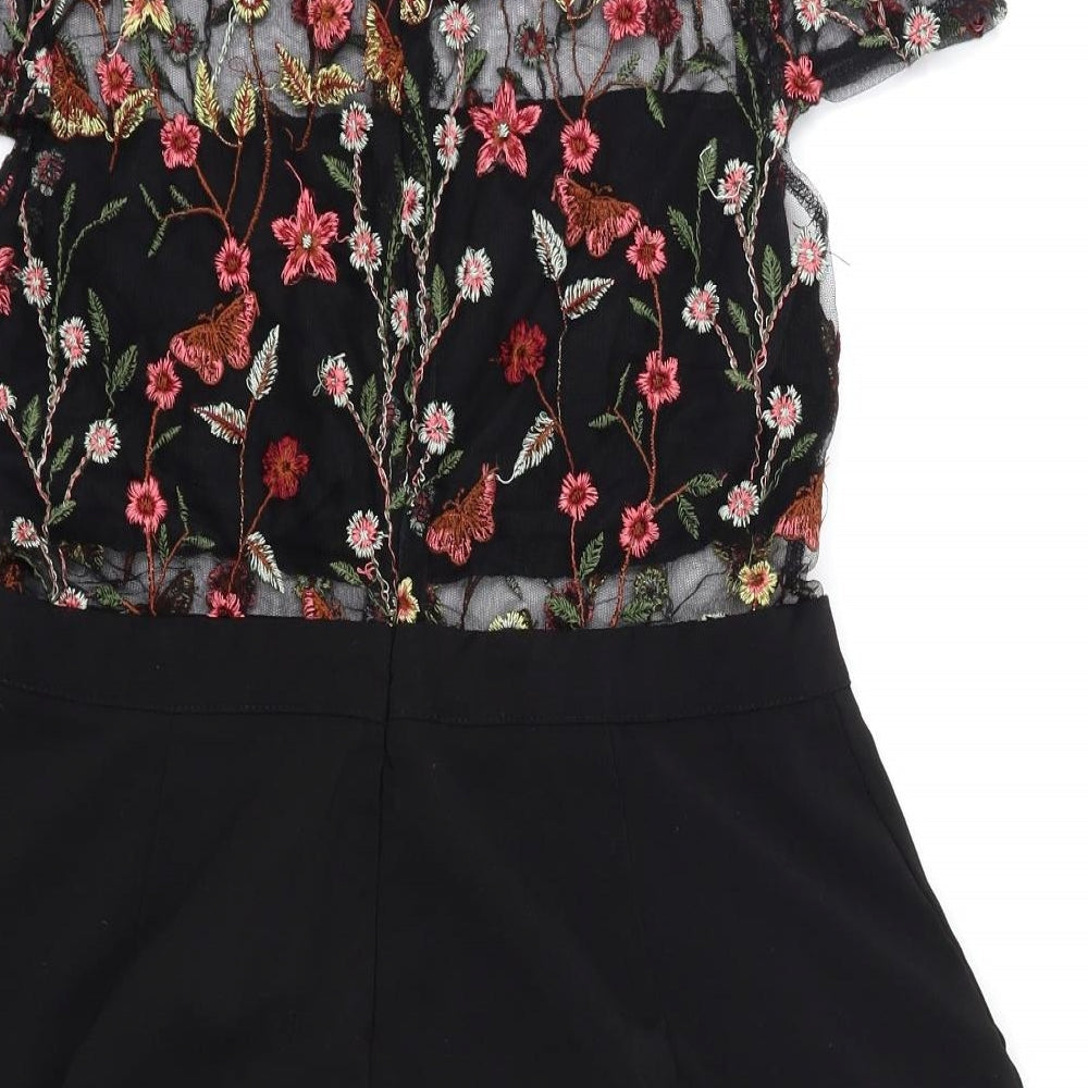 Brand and care label for in vogue Paris women’s black floral playsuit one-piece, size L