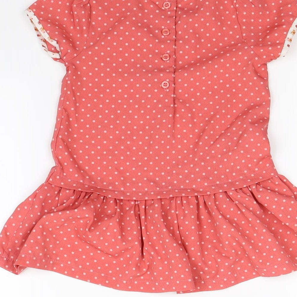 Brand and care label for Preworn girls’ pink spotted fit & flare, size 12, months