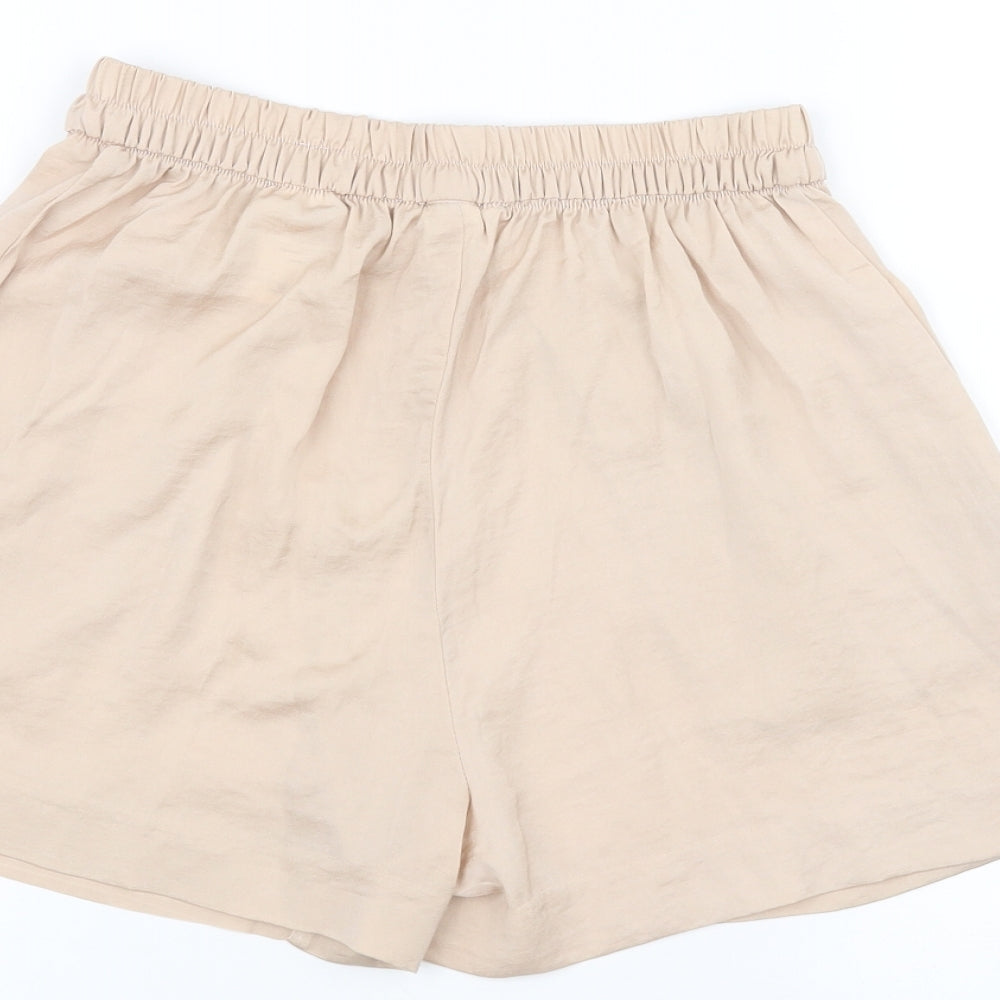 Brand and care label for H&M women’s pink paperbag shorts, size UK 4