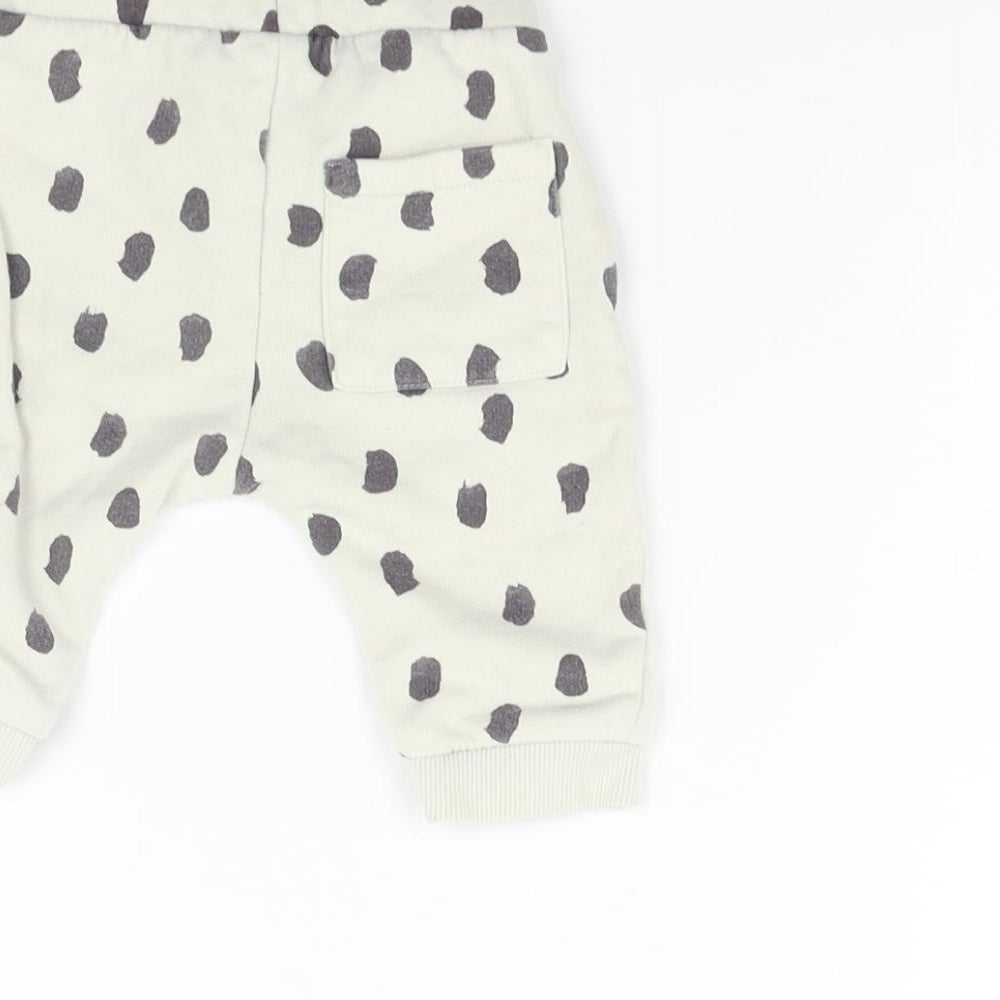 Brand and care label for Marks & Spencer boys’ beige animal print jogger trousers, size 3-6, months