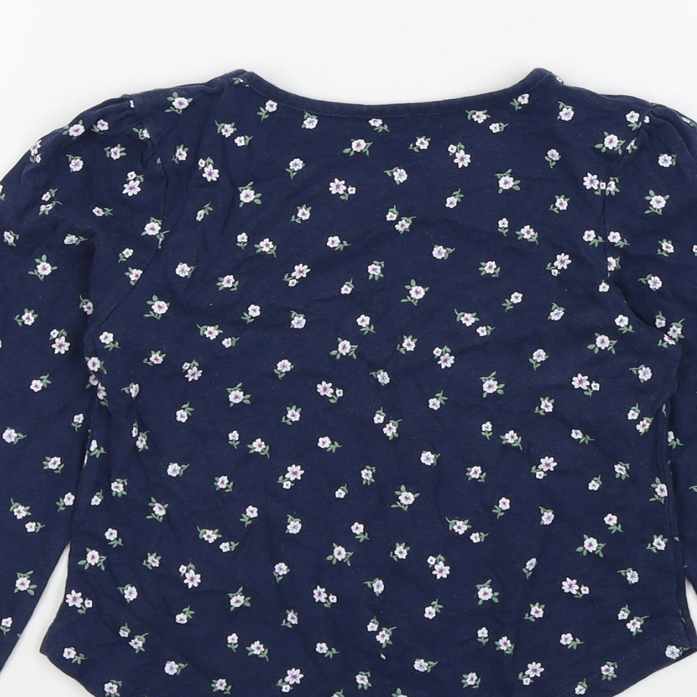 Brand and care label for Tu girls’ blue basic t-shirt, size 6, years - flower detail