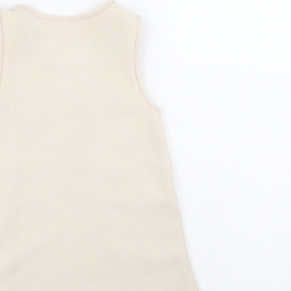 Brand and care label for Pick Ouic girls’ ivory pinafore/dungaree dress, size 18, months