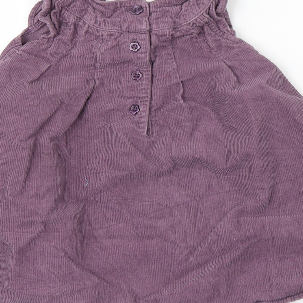 Brand and care label for Mini Club girls’ purple corduroy pinafore/dungaree dress, size 6-9, months