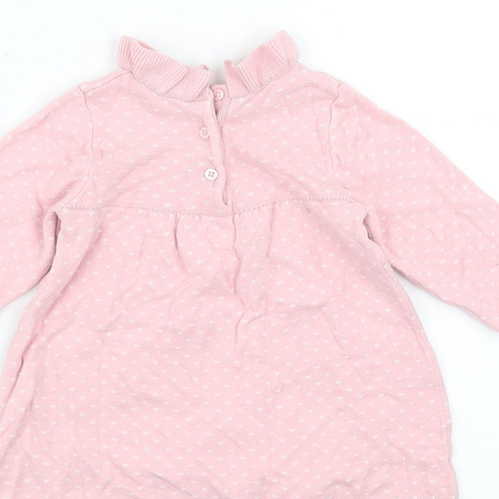 Brand and care label for Nutmeg girls’ pink jumper dress, size 6-9, months - heart pattern