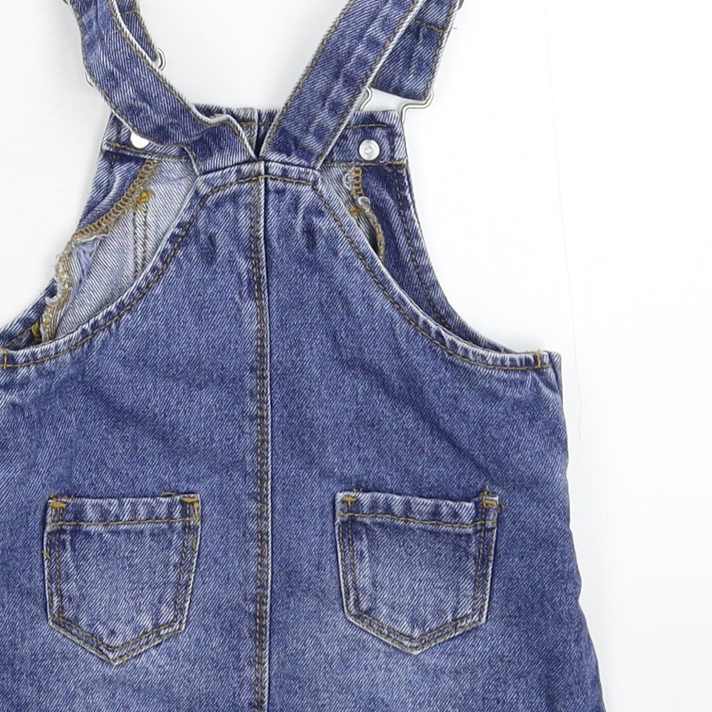 Brand and care label for Primark girls’ blue denim pinafore/dungaree dress, size 6-9, months