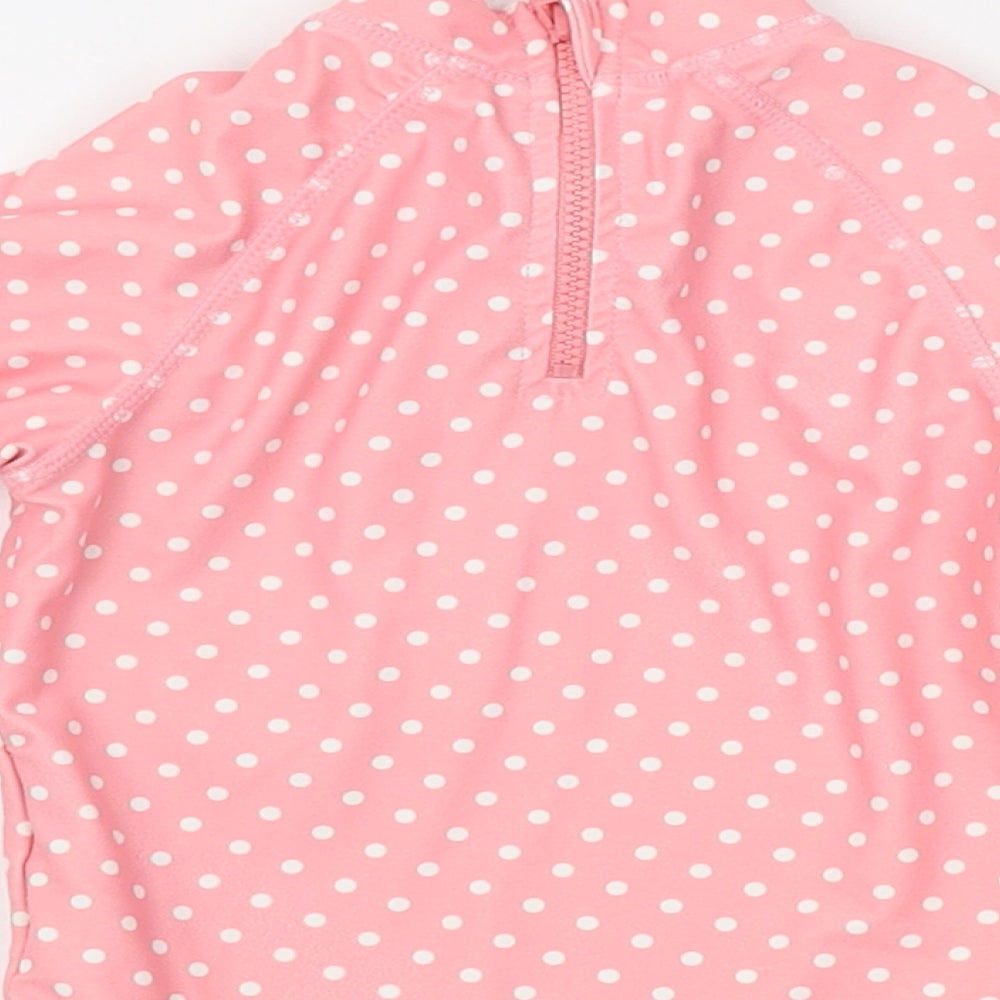 Brand and care label for Mothercare girls’ pink polka dot pyjama top, size 9-12, months