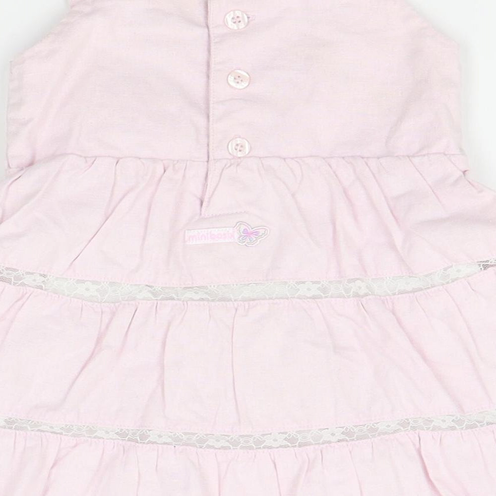 Brand and care label for minibasix girls’ pink pinafore/dungaree dress, size 9-12, months