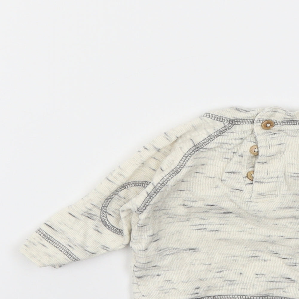 Brand and care label for Next boys’ ivory animal print jumper, size 0-3, months