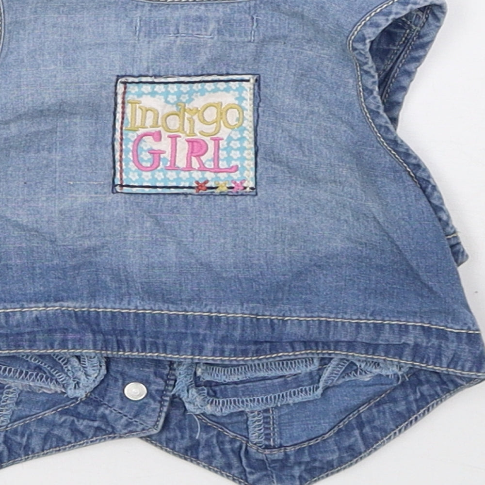 Brand and care label for Indigo girls’ blue gilet jacket, size 12-18, months