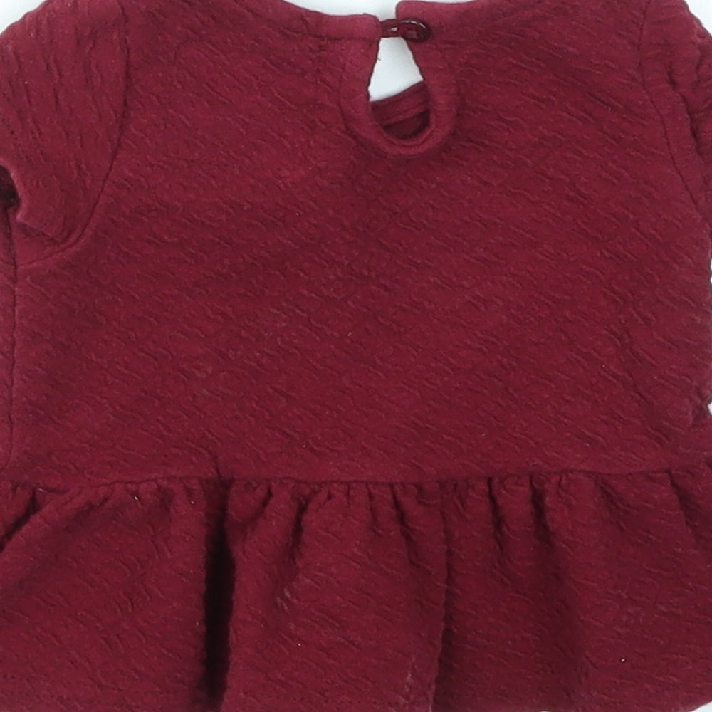 Brand and care label for Young Dimension girls’ red basic t-shirt, size 3-6, months