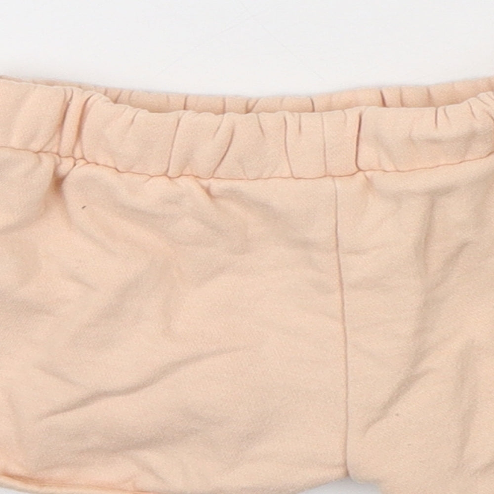Brand and care label for Disney girls’ pink cotton sweatpants, size 18-24, months - shorts