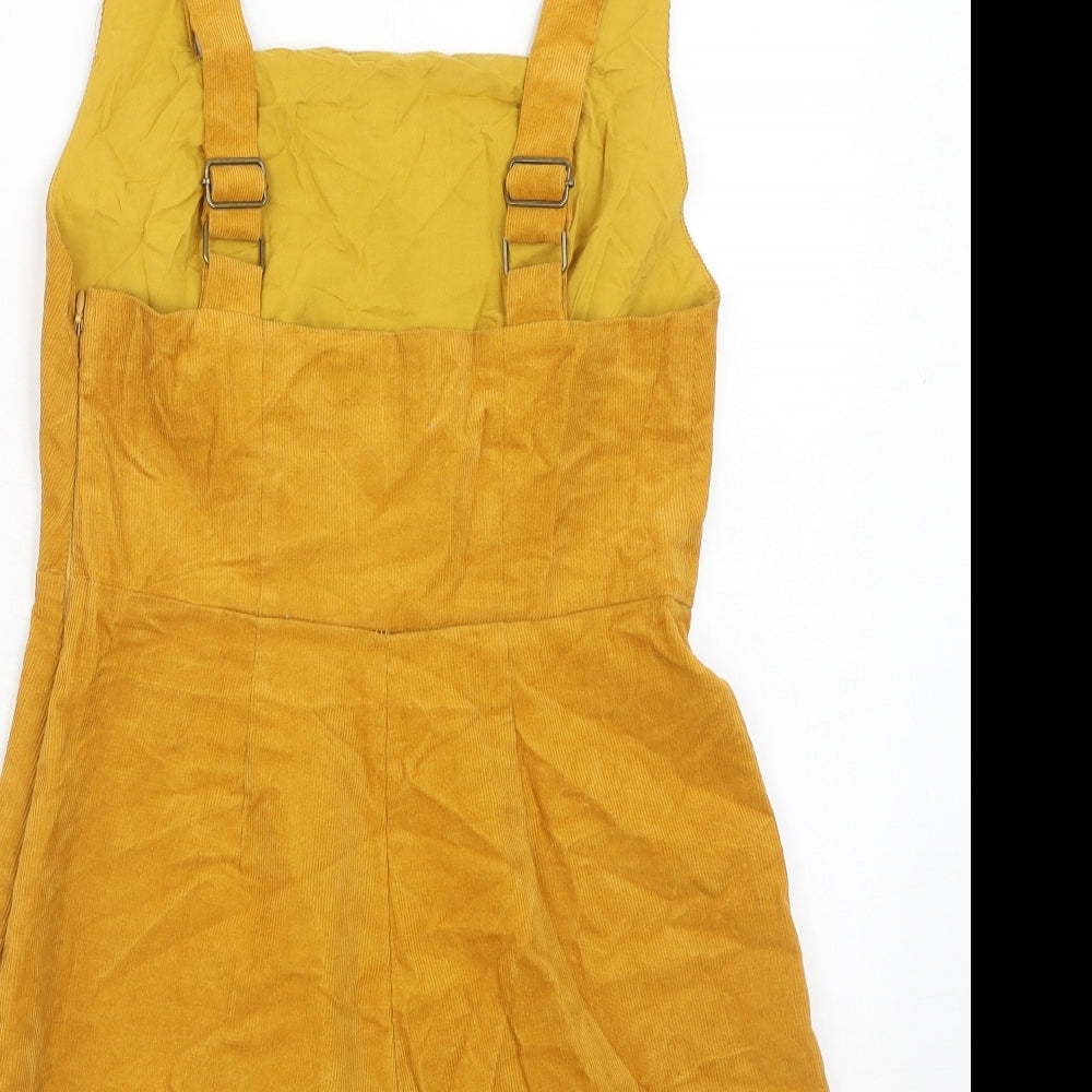 Brand and care label for BDG women’s yellow cotton playsuit one-piece, size M, button
