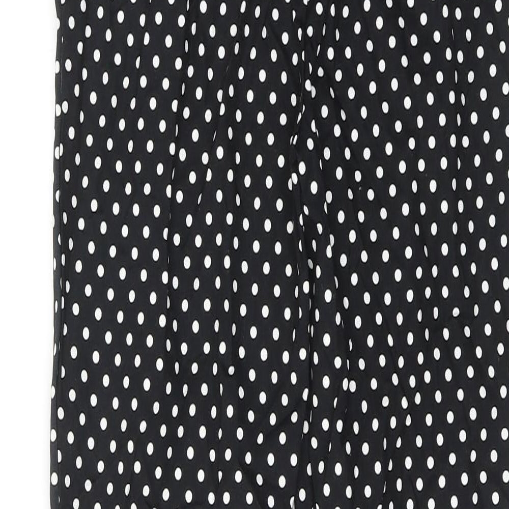 Brand and care label for ASOS women’s black polka dot cotton trousers, size XS, regular hook & eye