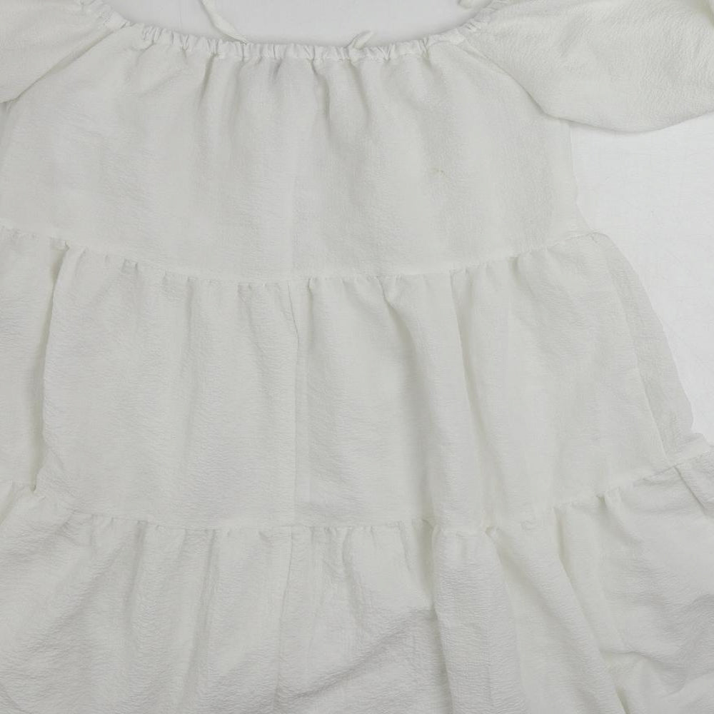 Brand and care label for In the Style women’s white polyester mini, size UK 10, off the shoulder pullover