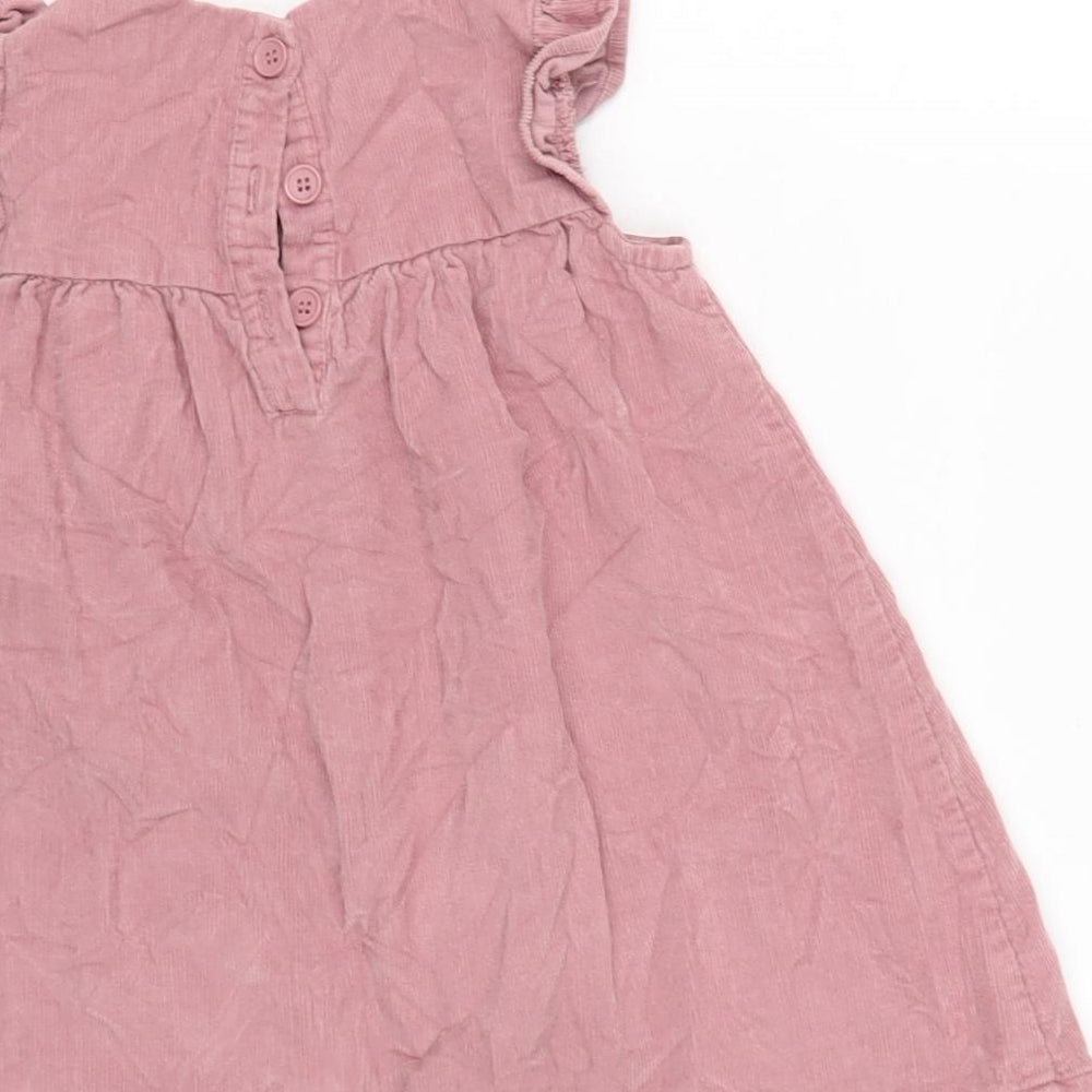 Brand and care label for George girls’ pink cotton pinafore/dungaree dress, size 18-24, months crew neck button