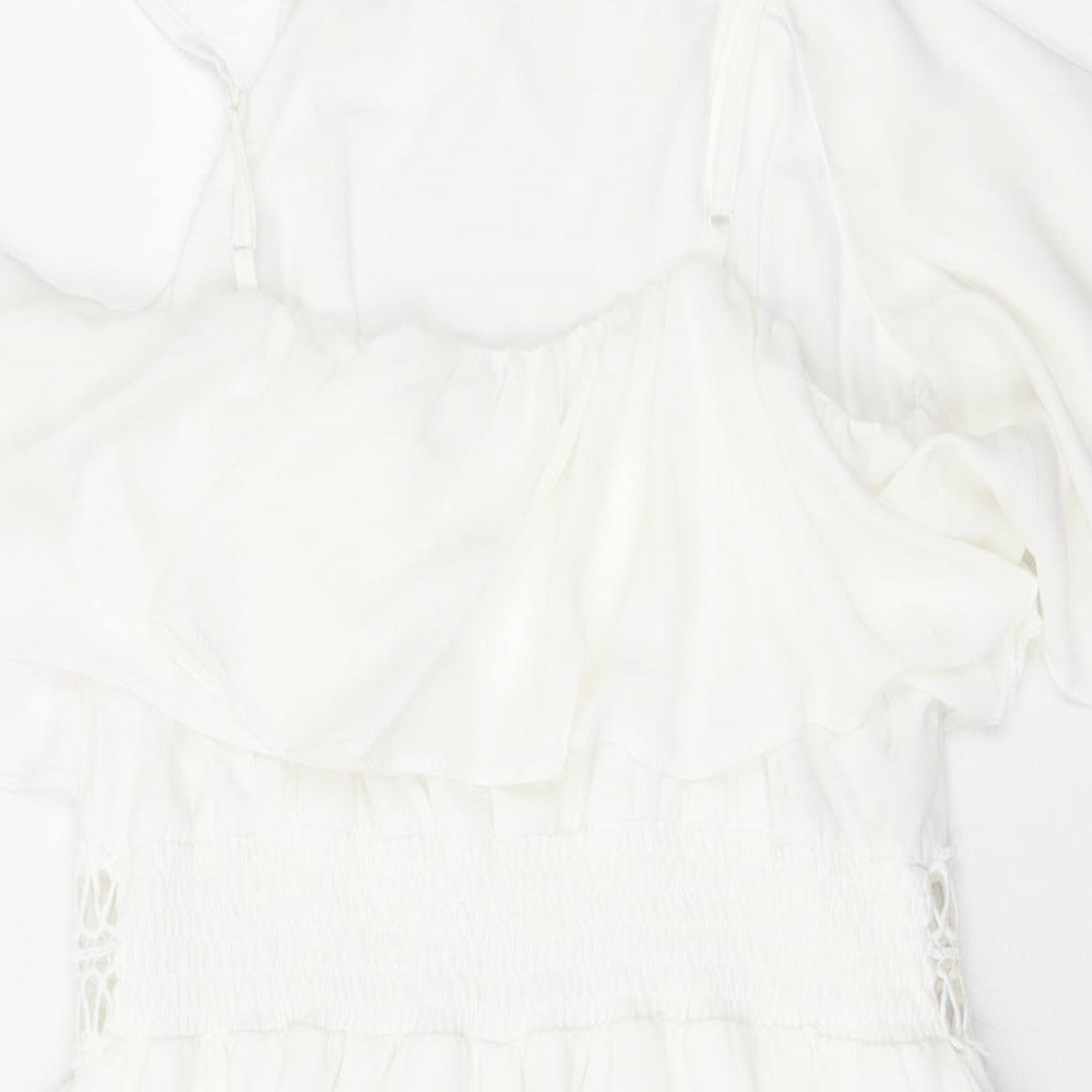 Brand and care label for Miss Selfridge women’s white polyester playsuit one-piece, size UK 10, pullover
