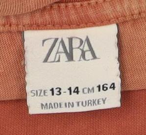 Close-up detail of Zara girls’ orange long sleeve bear graphic t-shirt 13-14 years