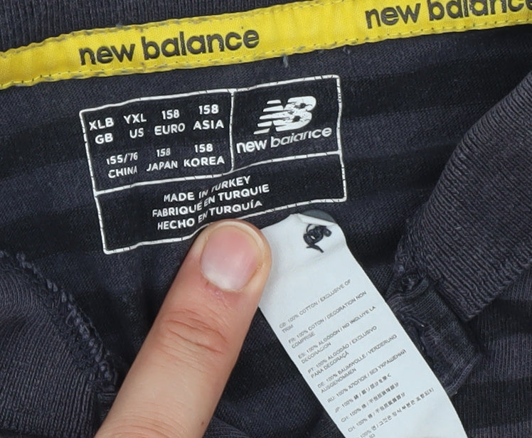 Close-up detail of New Balance boys’ black striped polo shirt, size 158, sports style