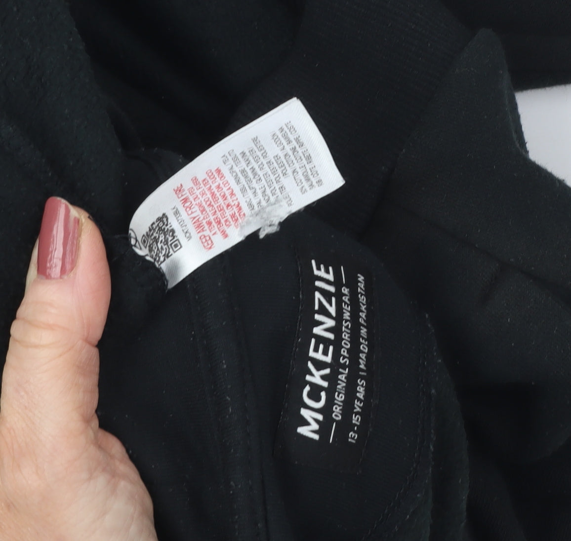 Close-up detail of McKenzie boys’ black hoodie 13-14 years pullover logo design