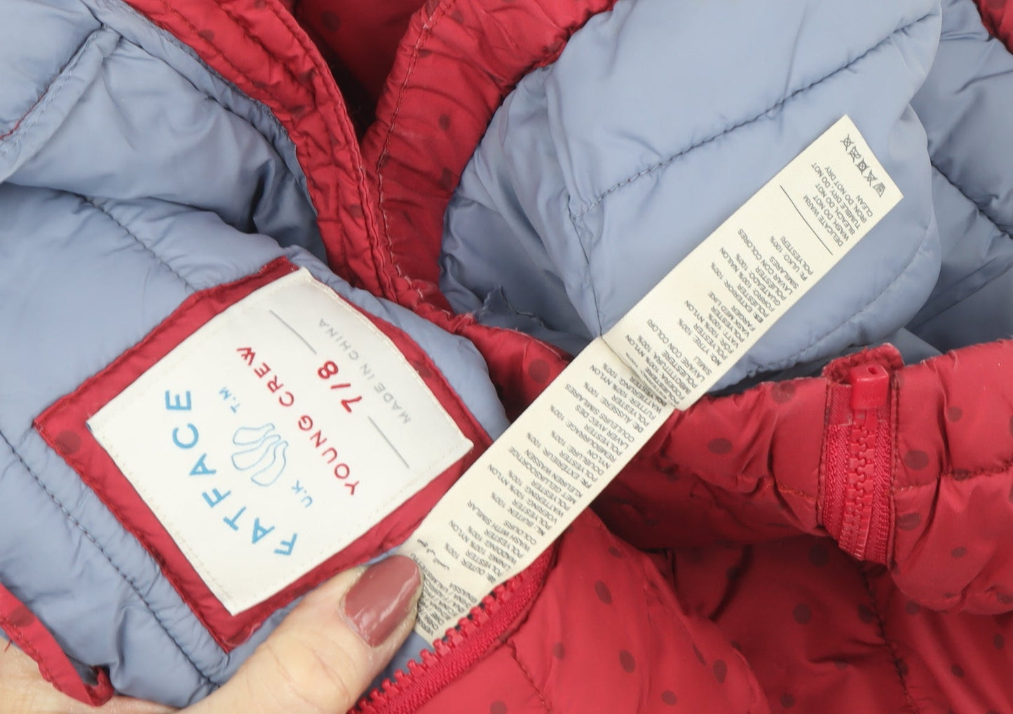 Close-up detail of FatFace girls’ red polka dot puffer jacket 7-8 years