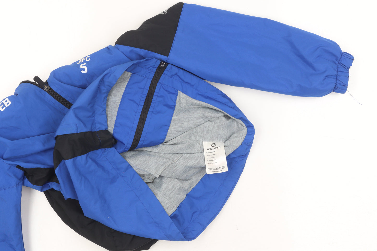 Brand and care label for Stanno boys’ blue windbreaker jacket, size 11, hooded