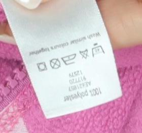 Brand and care label for Cherokee girls’ pink fleece jacket, size 12-13, years