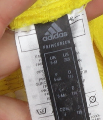 Brand and care label for Adidas boys’ yellow athletic shorts 5-6 years breathable