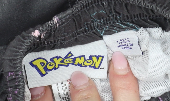 Brand and care label for Pokémon boys’ black swim shorts, size 2, years