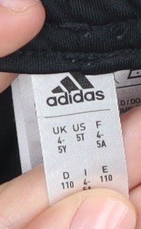 Brand and care label for Adidas boys’' black athletic football shorts 4-5 years