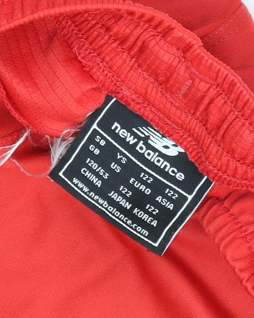 Brand and care label for New Balance boys’ red athletic shorts - 7-8 years