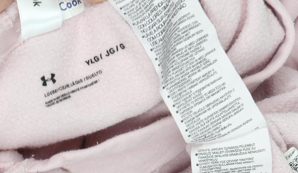 Close-up detail of Under Armour girls’ pink pullover hoodie –, size L, sports style