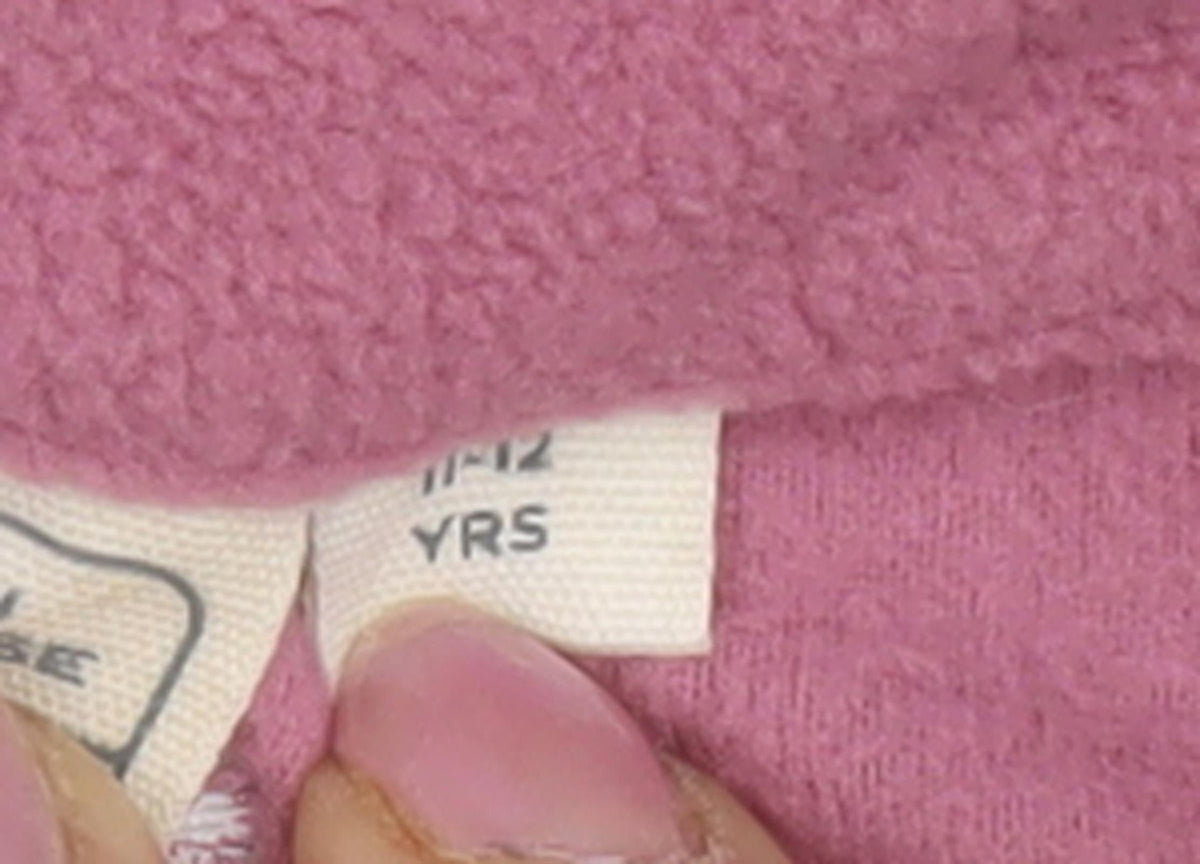 Brand and care label for Mountain Warehouse girls’ pink fleece full zip hoodie 12 years