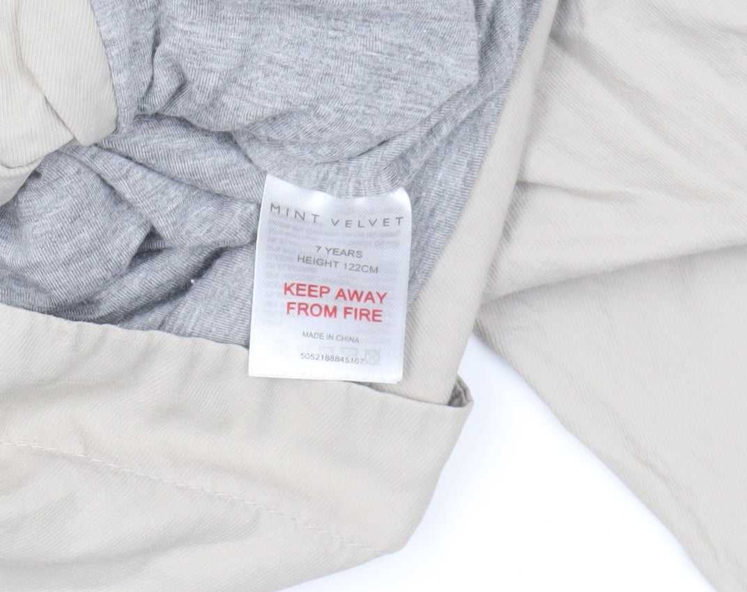 Brand and care label for Mint Velvet girls’ beige parka jacket with hood, size 7, years