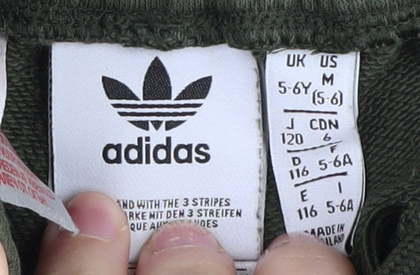 Brand and care label for Adidas boys’ green athletic shorts 5-6 years