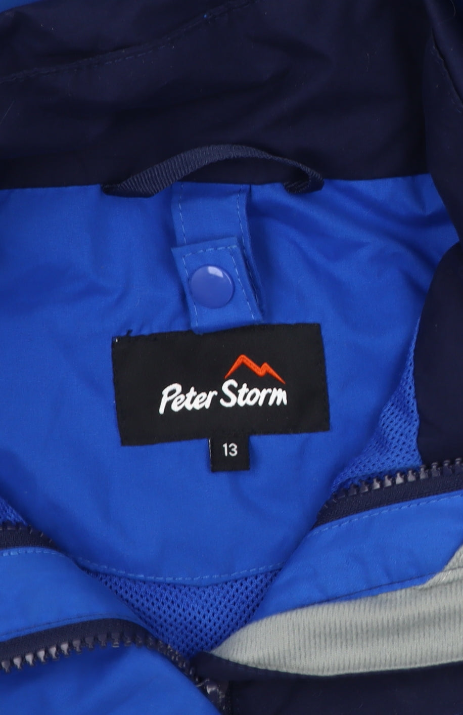 Close-up detail of Peter Storm boys’ blue colourblock rain coat 13 years hooded