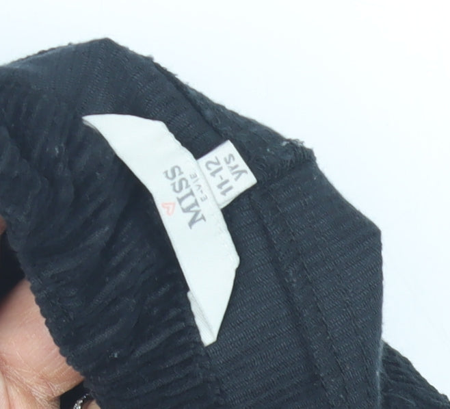 Brand and care label for Miss Evie girls’ black corduroy skirt 11-12 years