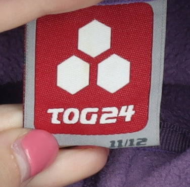 Brand and care label for TOG24 girls’ purple fleece jacket ages 11 years casual