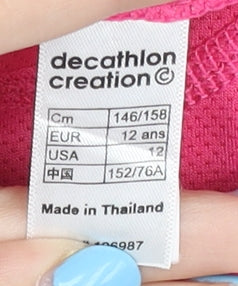 Brand and care label for Decathlon girls’ pink t-shirt, size 18 plus, lightweight sports top