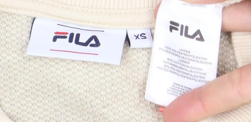 Brand and care label for Fila women’s beige xs pullover sherpa fleece sweatshirt