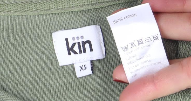 Brand and care label for Kin Women’s Green XS Pullover Sweatshirt 100% Cotton