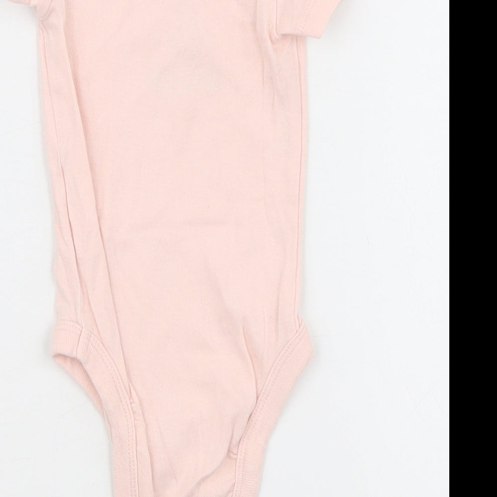 Brand and care label for Looney Toons girls’ pink babygrow one-piece, size 0-3, months