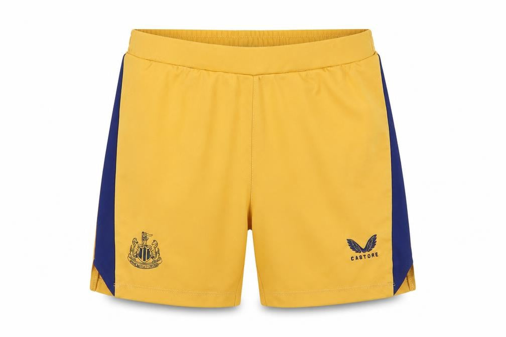 Front view of Castore boys’ gold athletic football shorts l