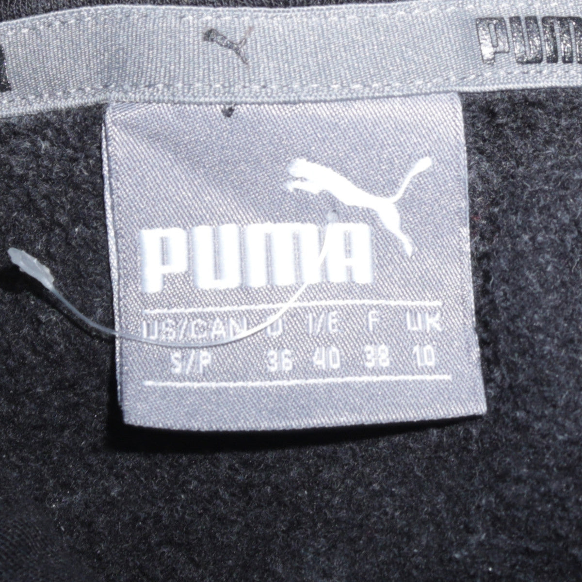 Brand and care label for PUMA women’s black hoodie, size UK 10, pullover hooded sweatshirt