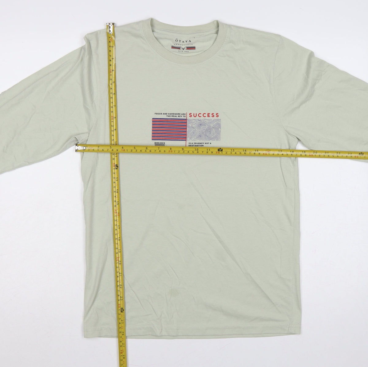 Close-up detail of O'Taya Men's Green L Graphic Success Long Sleeve Crew Neck T-Shirt