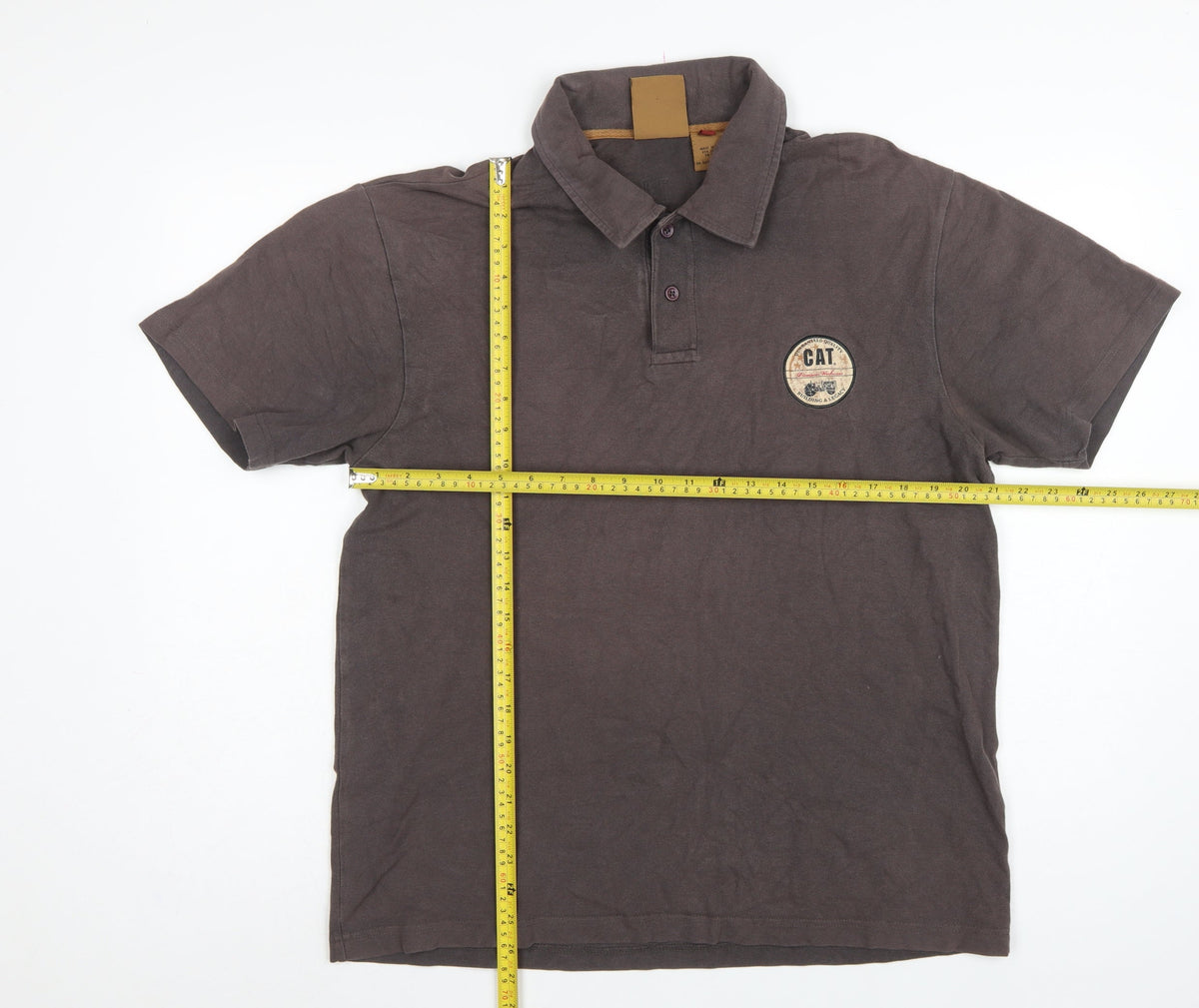 Close-up detail of CAT men’s brown l premium workwear logo short sleeve polo shirt
